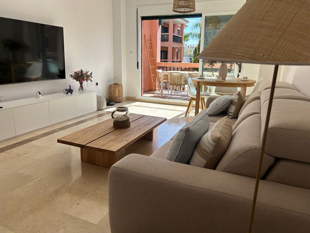Salón comedor completo con sofá, TV y acceso a terraza