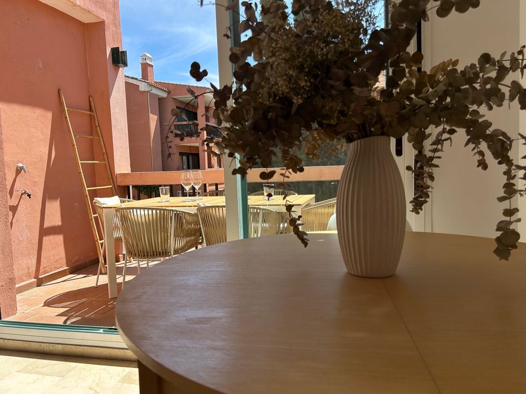 Vista terraza exterior con mesa y vinos